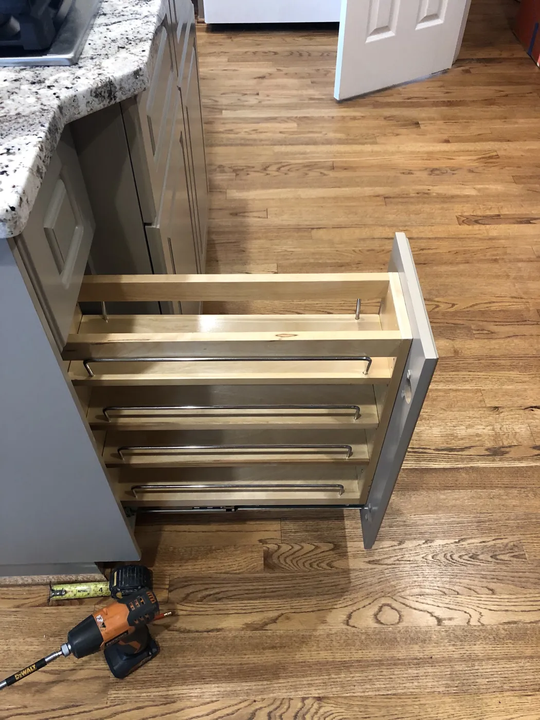 A pull-out cabinet being fitted beside a granite counter
