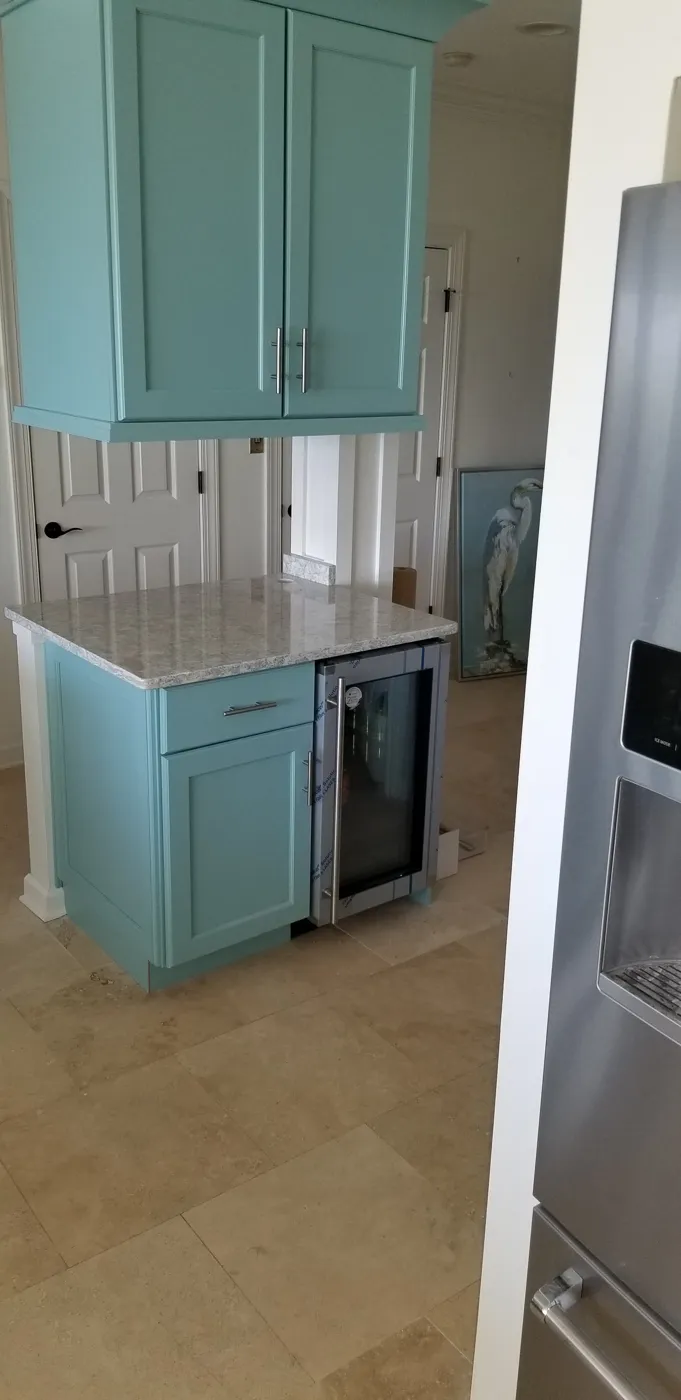 Teal cabinets built around a wine fridge