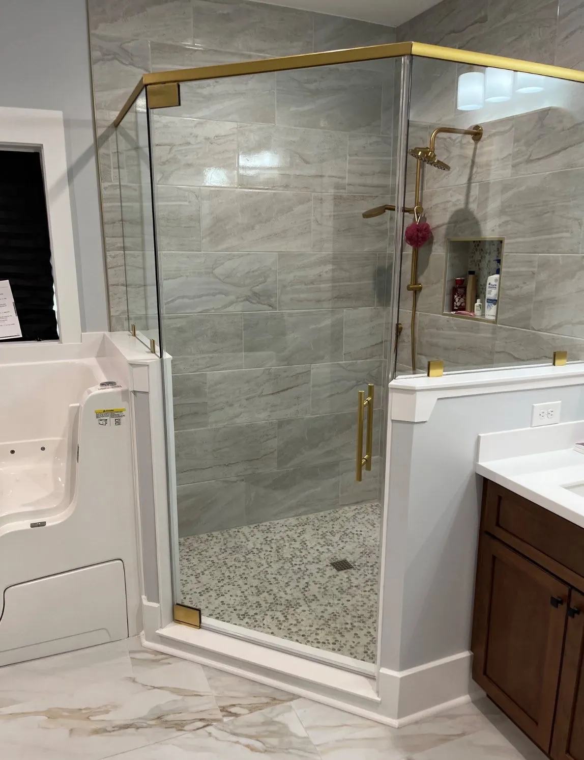A corner shower with brass fittings in a new custom home