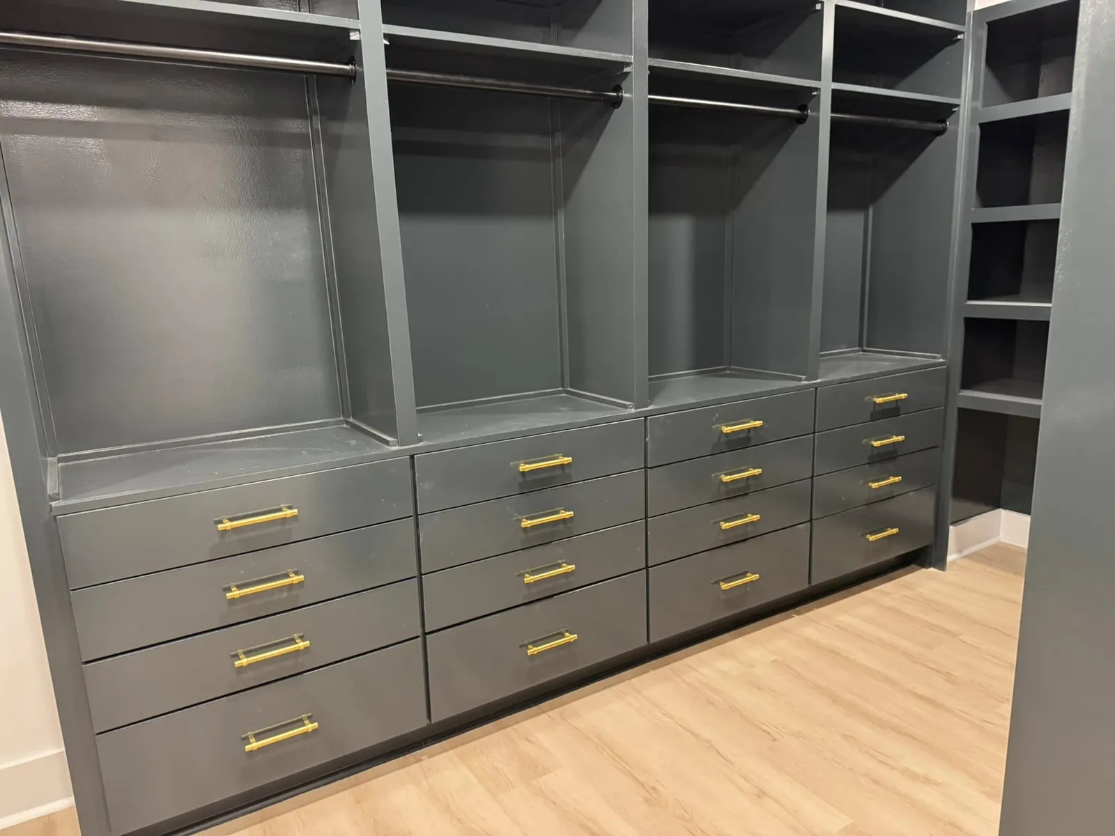 A custom walk-in closet with brass pulls