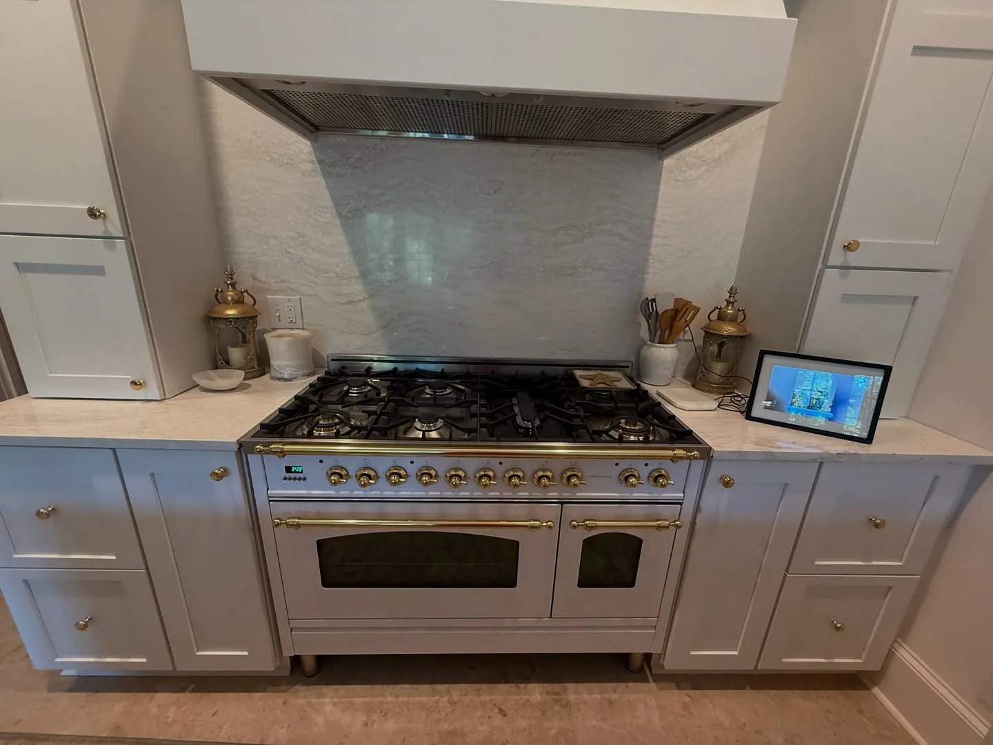 A six-burner range under a custom plaster hood