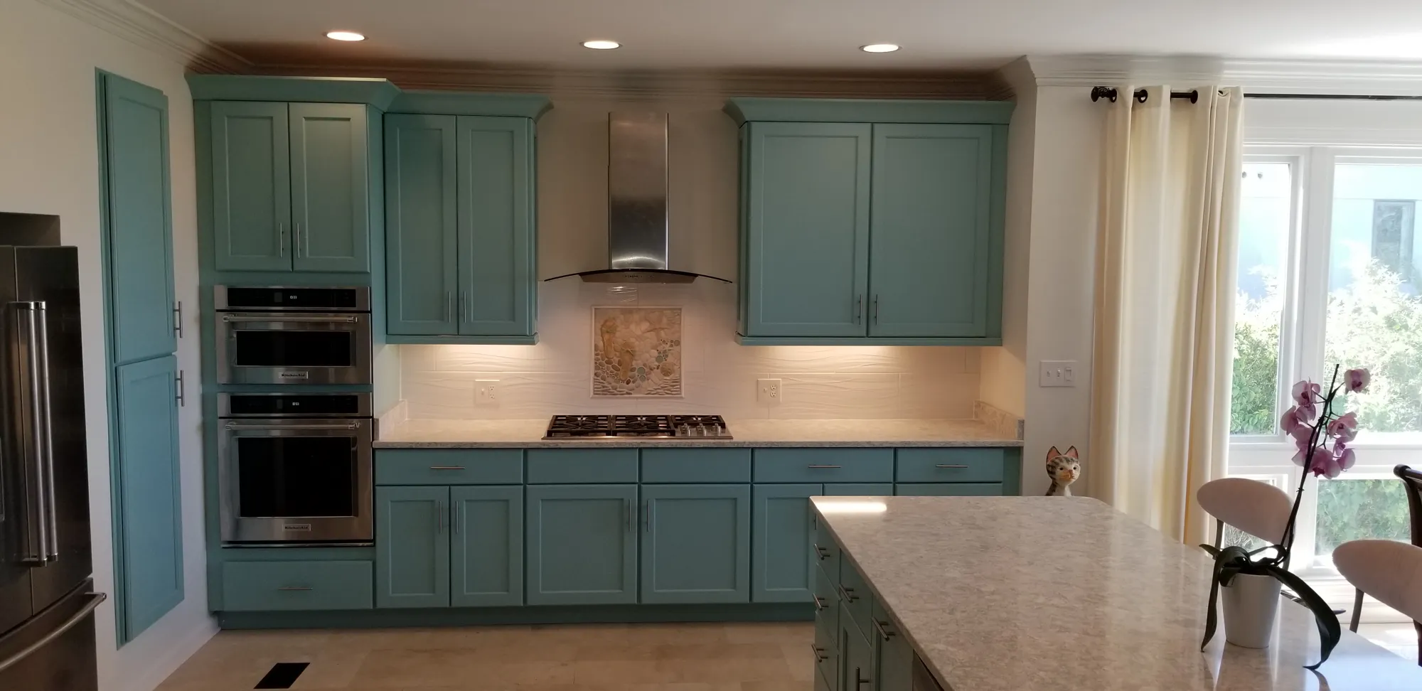 Teal cabinets, stainless hood and a quartz island